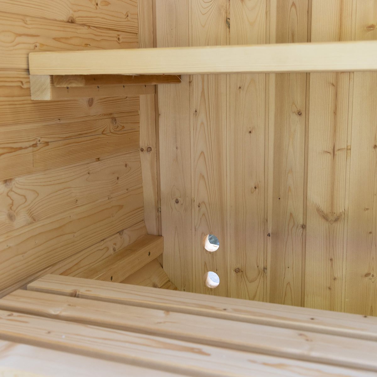 Wooden sauna interior with bench and shelves.
