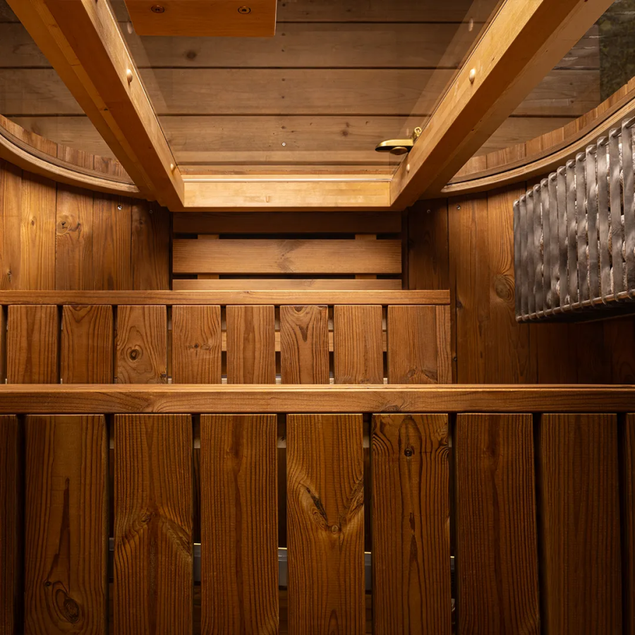 Wooden sauna interior with wooden benches and ceiling.